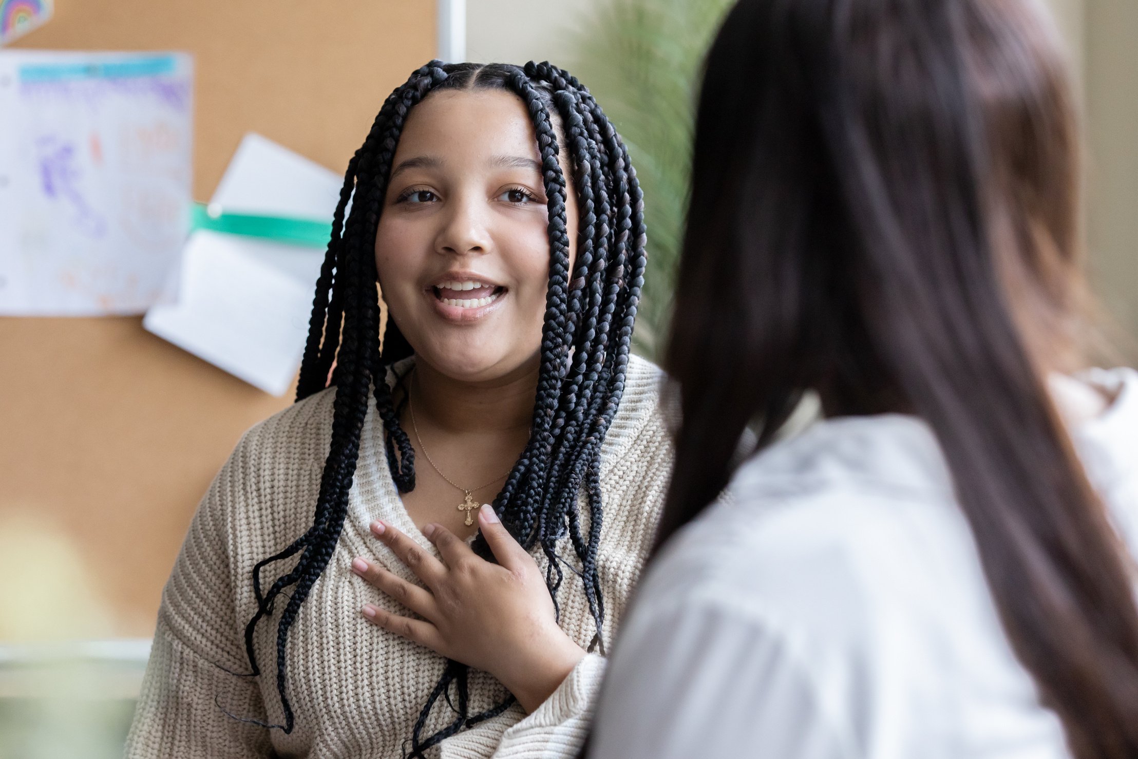 Middle school student meets with teacher or counselor in classroom